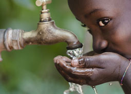 Kind trinkt aus Wasserhahn